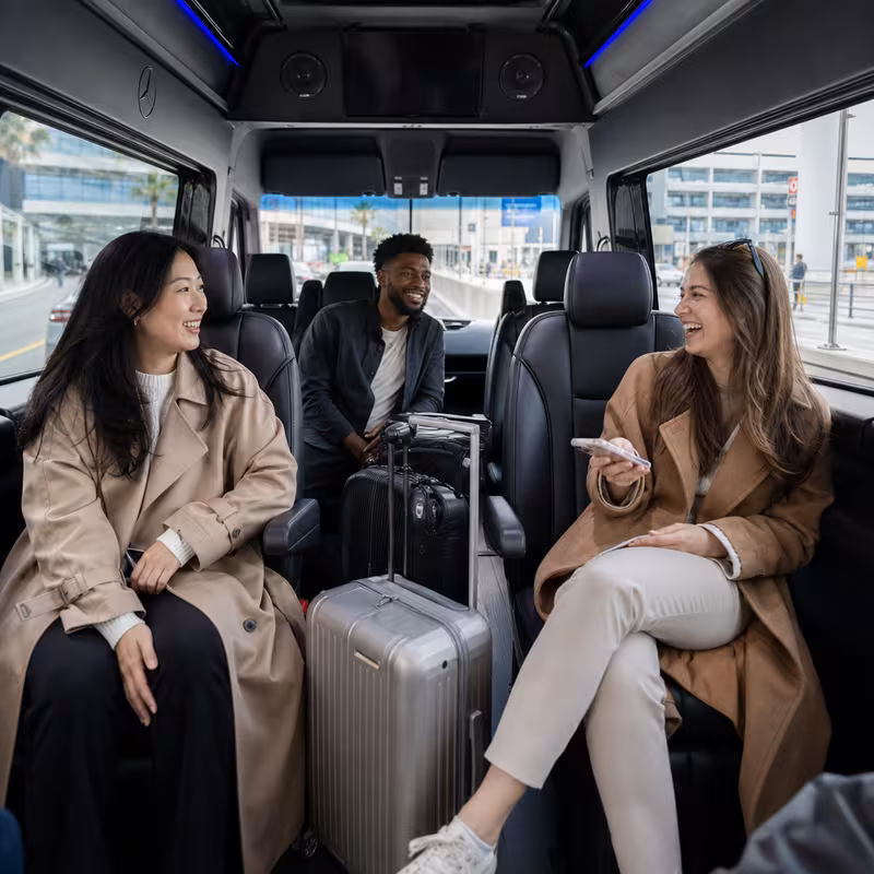 Passengers loading luggage while boarding a Long Beach group shuttle