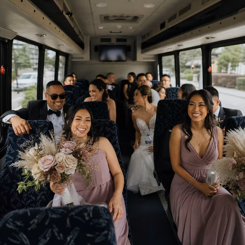 Group boarding a white charter bus for Wedding Transportation transportation in Long Beach